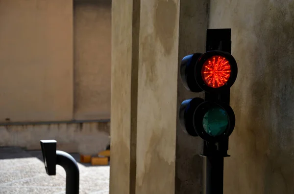 traffic light with two lights. placed on a metal gray facade of a garage or warehouse. used to enter trucks to the loading ramp for goods. regulates the entrance to garages of shopping center, yard