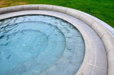 Parkta gezinti, olukta yapay akış. Fıskiyeler, fıskiyeler, fıskiyeler, fıskiyeler. mavi klorlu suyla bej gölet