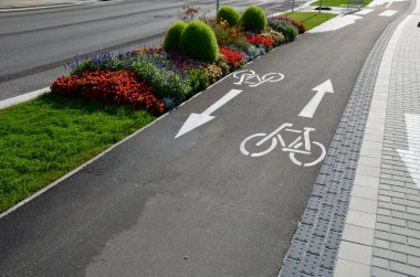 promenade for pedestrians and cyclists with a dividing island between the lanes and road, road markings sprayed with paint on asphalt. wheel, arrow and triangle traffic sign pictogram. luxury spa