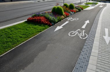 promenade for pedestrians and cyclists with a dividing island between the lanes and road, road markings sprayed with paint on asphalt. wheel, arrow and triangle traffic sign pictogram. luxury spa