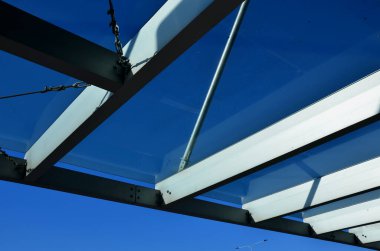 strut, suspended glass roof above the building entrance. bus station, railway station. cable wind braces. aluminum construction with windows above the pergola