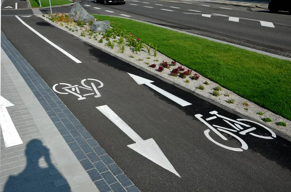 promenade for pedestrians and cyclists with a dividing island between the lanes and road, road markings sprayed with paint on asphalt. wheel, arrow and triangle traffic sign pictogram. luxury spa