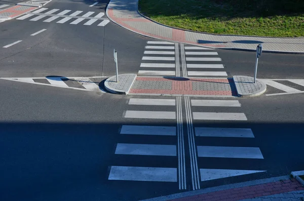 directionally divided lanes at intersection. crossing has a raised safety island for pedestrians. signage for blind. comprehensive traffic marking of street intersections. expertise transport studies