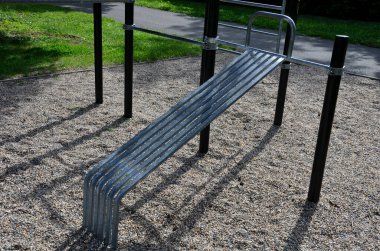 Paslanmaz çelik aletli fitness sahaları zincirli ve saplı işkence aletlerine benziyor. yumuşak kauçuk yüzey spor salonu. Adam makara tutuyor ve kaslarını güçlendiriyor.