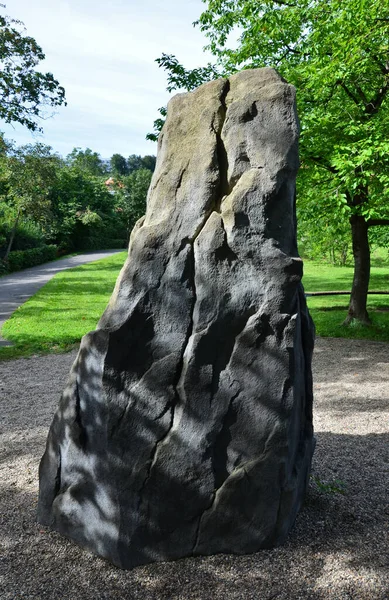 felt stone with surface treatment for training climbing. tooth-shaped boulder in a park in the city. an imitation of an adult-sized rock on a children's playground. there are crevices and grips