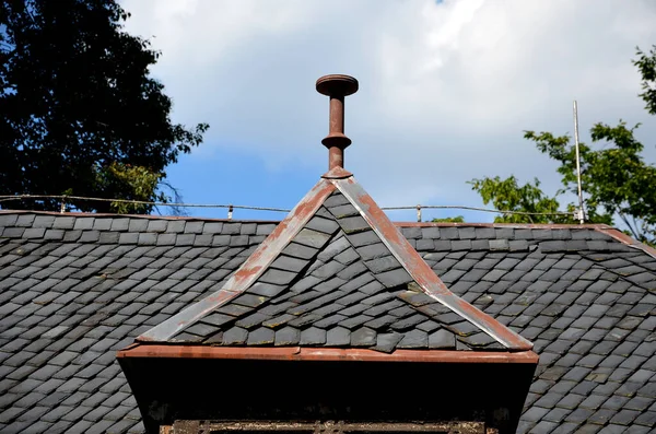 roofs lined with natural stone slate. typical for cottages and stately residences, castles and noble villas. turrets roofed with gray tiles similar to fish scales. the roofer must know how to work