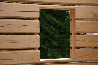 a carpenter built a log cabin with rough hewn beams. wood planing was not done before. authentic craftsmanship wooden log cabin. mortises for placing roof beams. gouging wood, ax, cut