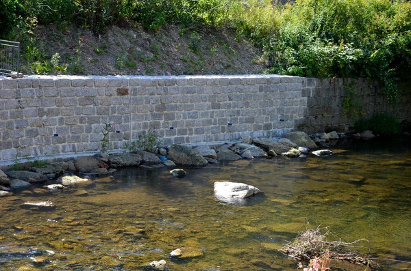 restoration of the retaining wall directly above the mountain stream. stones. the water-soaked wall needed to be repaired and the joints filled with cement mortar. mountain stream with round stones