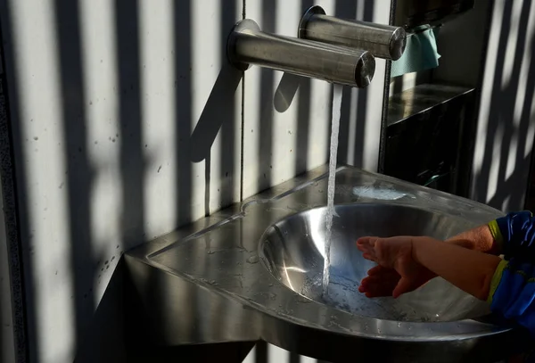 stainless steel sink with automatic battery reminds the interior of an airplane. however, it is on the bike path by the public toilets. There is also a changing table for babies, folded out