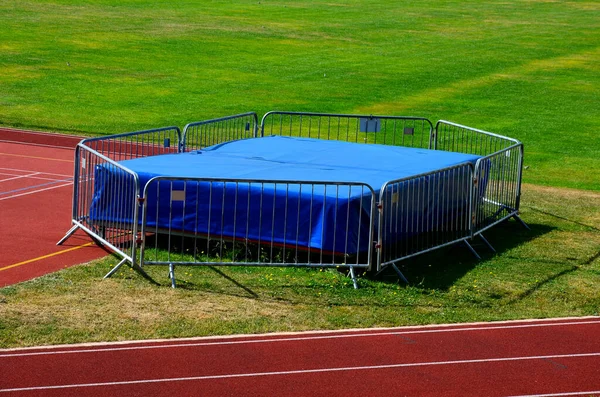 an obstacle course for athletes, a high jump into a mattress in the school yard. a running oval with marked lanes with numbers for five runners