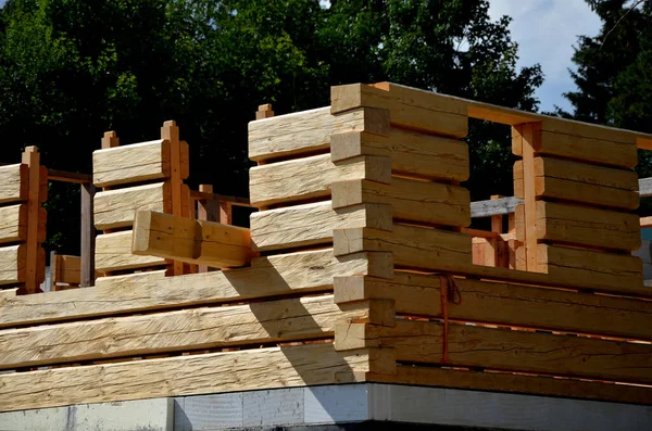 a carpenter built a log cabin with rough hewn beams. wood planing was not done before. authentic craftsmanship wooden log cabin. mortises for placing roof beams. gouging wood, ax, cut, pull strap