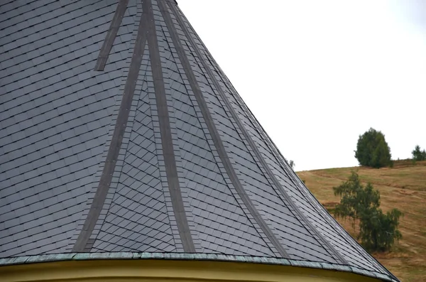 roofs lined with natural stone slate. typical for cottages and stately residences, castles and noble villas. turrets roofed with gray tiles similar to fish scales. the roofer must know how to work