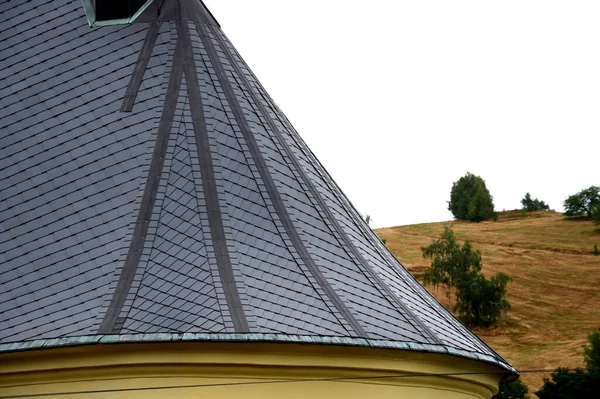 roofs lined with natural stone slate. typical for cottages and stately residences, castles and noble villas. turrets roofed with gray tiles similar to fish scales. the roofer must know how to work