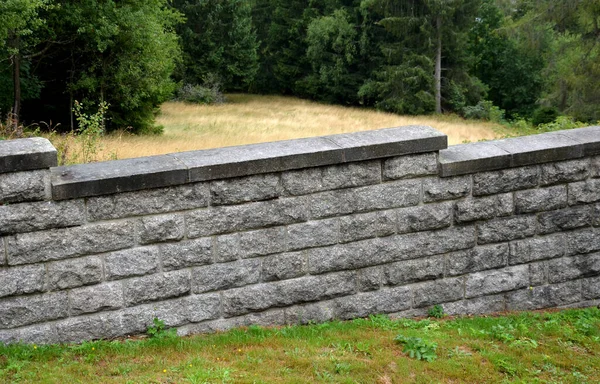 repaired renovated sandstone walls near the cemetery. stairs and railings of the wall made of new stone which weatheres quickly but is beautiful and beige from large easily workable blocks.  sloping