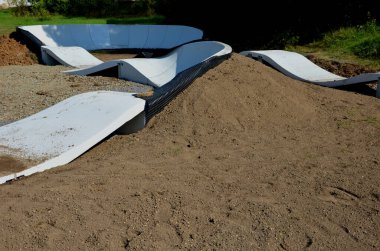 Otoparktaki bisiklet yolu Pompalama pedal çevirmek ve zıplamak yerine modüler pompa pisti boyunca bisiklet, scooter, kaykay ve dahili patenleri hareket ettirmek için kullanılır.