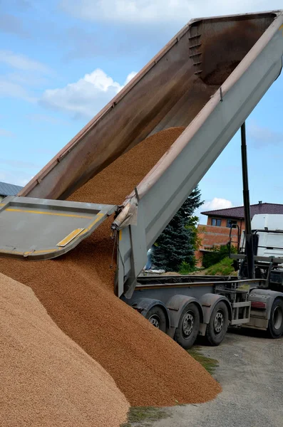 heavy load car. dump a load of gravel into a large pile. A metal hopper in the shape of a trough or tub can transport tens of tons of stone. three-axle semi-trailer. on a building site, unload
