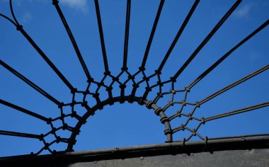 Pencere, kapı, bina, kemer şeklinde bir açıklık. Siyah metal kablolardan örülmüş, fan şeklinde. bükülmüş kafes süsleri. Bahçenin barok kapısı.