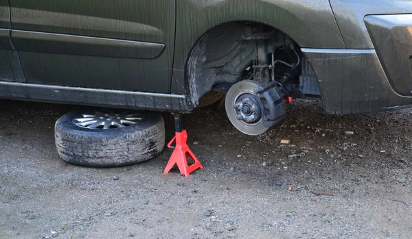 İç koşullarda arabada fren diski değiştirmek. Tamirci yıpranmış frenleri çıkarır ve yenilerini takar. Aletleri ve montaj yastığı var, dur, vale