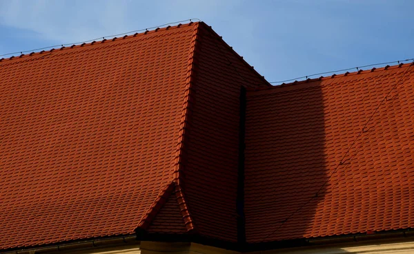 roofs lined with natural burnt. typical for cottages and stately residences, castles and noble villas. turrets roofed with red tiles similar to fish scales. the roofer must know how to work