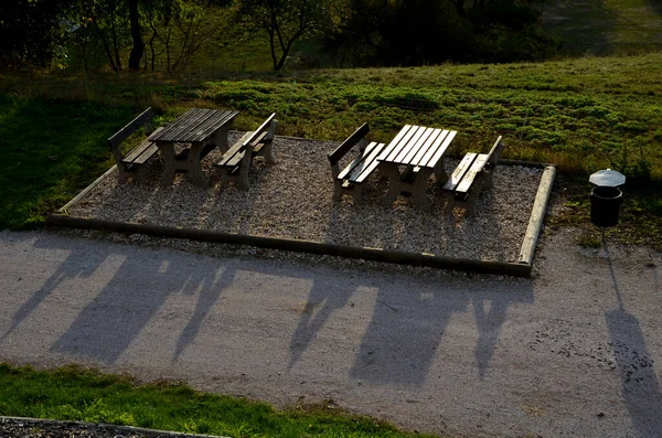 공원의 산책로에 의자들 통나무를 지지하는 콘크리트 벤치입니다 배경에는 다년생 침대와 — 스톡 사진