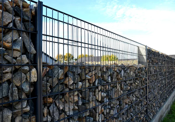 建造加布里安挡土墙 作为房屋围护结构的一部分 填充在两根金属丝板之间 石头在网状物中间窥视 — 图库照片