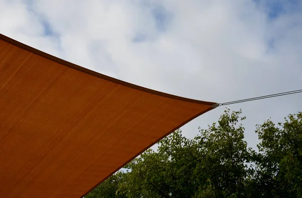 square canvas stretched, shading from sun and rain over terrace ofrestaurant, on playground in kindergarten, on platform of the promenade. pergola with metallic gray beams , cable, electric, bulb, led