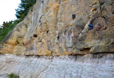 Kayanın derinliklerine demir atmış çelik bir ağ ile yamacı güçlendiriyor. Düşen kayalar yola düşmez. Çelik çivili fındıklı. Toprağın altını delip ağı sıkıca bağlayın.