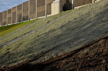 Su ekerek yamaçların dengelenmesi. Ahşap hamuru ve yeşil çim tohumu karışımı doğrudan çıplak topraktan püskürtülür. Bir kabuk tohumu, bariyer otoyolu, drenaj, erozyon kontrolü oluşturur