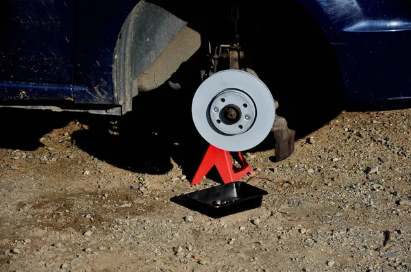 replacement of the brake disc at the car in domestic conditions. the car repairman removes the worn brakes and puts on new ones. has tools and a mounting pad