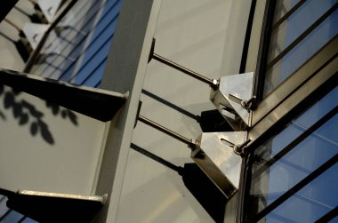 Caddedeki metal kirişlere gömülmüş köprüdeki çizgili camlardan oluşan ses geçirmez bir duvar. Pencereleri basınç vidalarıyla onarıyorum. Gözenekli bloklar yol üzerinde eğimli, çapraz, ayrıntı