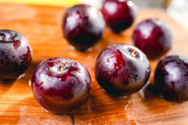 Kesme tahtasında taze siyah erikler