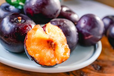 Kesme tahtasında taze siyah erikler