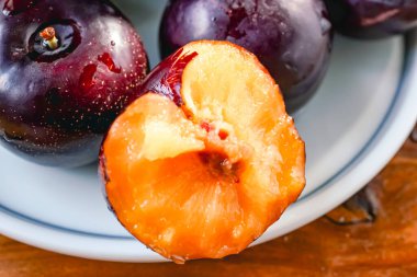 Kesme tahtasında taze siyah erikler