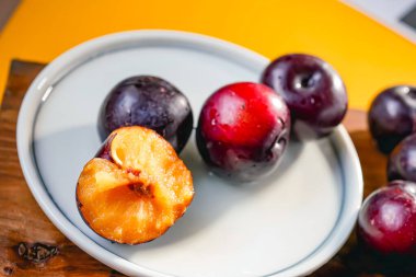 Kesme tahtasında taze siyah erikler