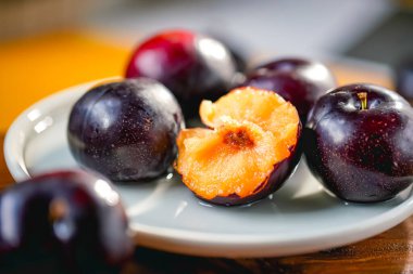 Kesme tahtasında taze siyah erikler