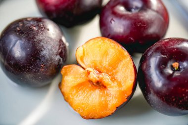 Kesme tahtasında taze siyah erikler