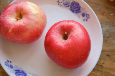 Taze kırmızı Fuji elmaları tabakta