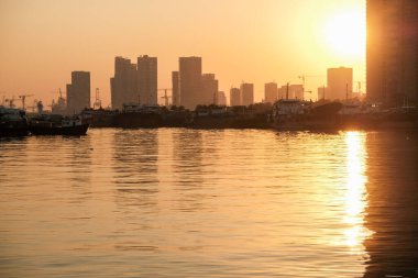 Şehrin su yüzeyindeki günbatımının yansıması.