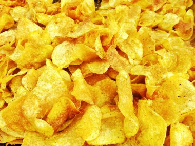 Lezzetli kızarmış patates cipsleri, dilimlenmiş sarı çıtır çerezler baharatlı baharatlı patatesler, yüksek kalorili sağlıksız yiyecekler, abur cuburlu patates cipsleri sizi şişmanlatır, bağımlılık yapar ve sık sık yersiniz.