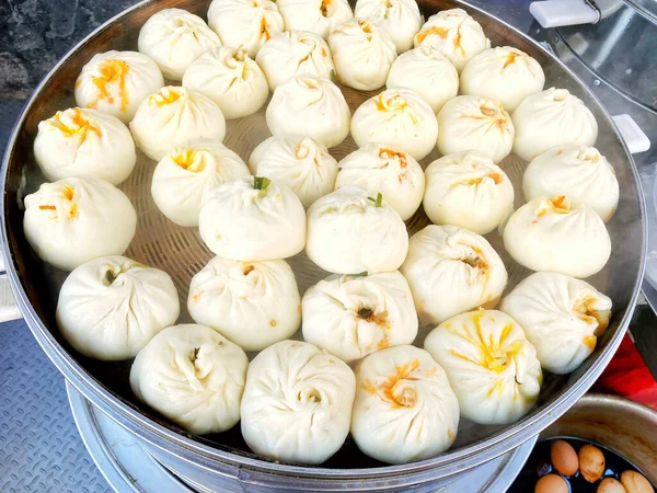 Steamed steamed buns in a cage, traditional Chinese breakfast food in Asian countries, rich in nutrition, with meat and greens fillings and various ingredients, various flavors
