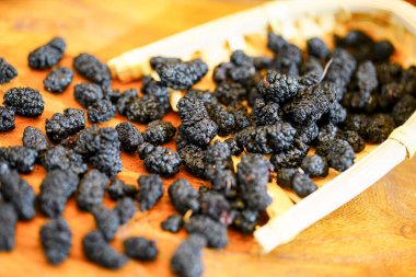 Masada doğal olarak kurutulmuş bir sürü siyah kurt üzümü var.