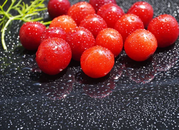 Cherry fruit on a black background with water drops - a beautiful background with organic food.