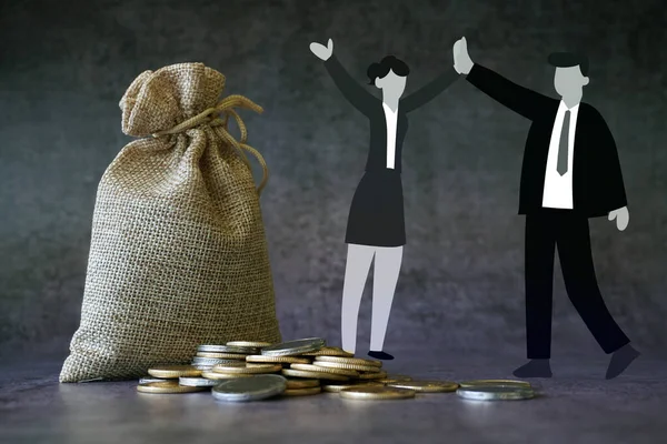 Business man and woman celebrating success Money Bag and Coins. Stock Photo