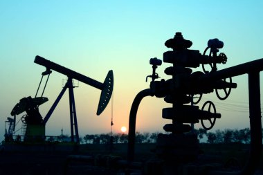 Tarlada, akşamları petrol boru hattında, akşamları petrol boru hattı siluetinde.