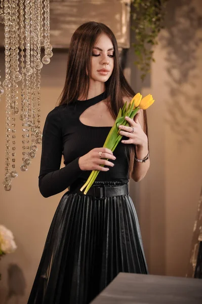 Gyönyörű Fiatal Hosszú Hajjal Fekete Ruhában Virágcsokorral — Stock Fotó