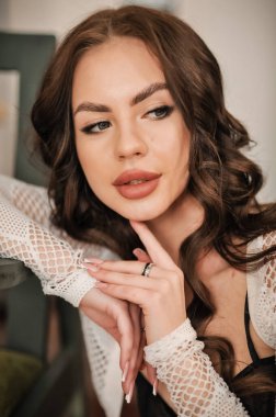 Stüdyoda poz veren uzun kıvırcık saçlı güzel bir kadın.