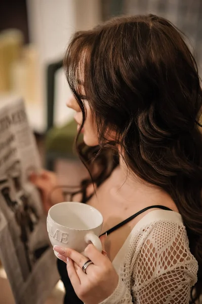 young beautiful woman with cup of coffee in the cafe