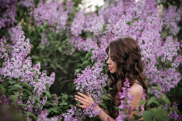 beautiful young woman in a lilac dress in the garden