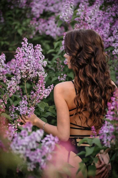 庭のピンクのドレスを着た美しい若い女性 — ストック写真