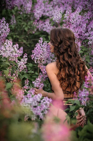 美丽的年轻女子 一头长长的头发 穿着粉红色的衣服在花园里 — 图库照片
